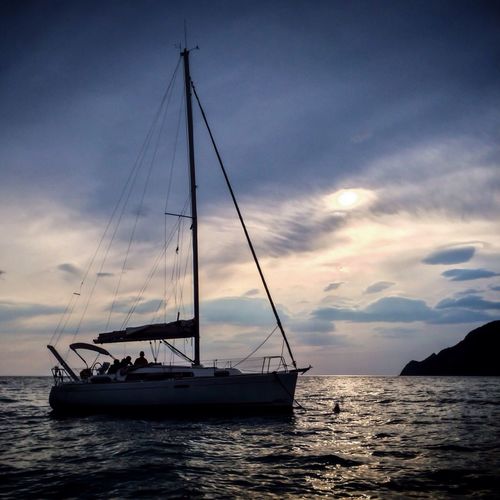 Sailboat in sea at sunset