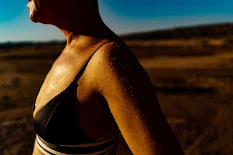 Midsection of woman sweating at land during sunny day