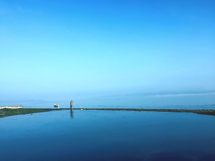 Scenic view of sea against clear blue sky