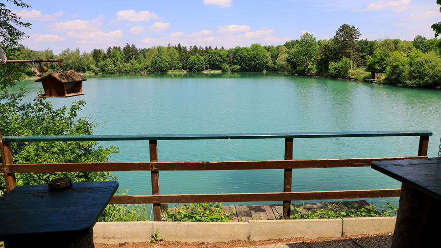 Scenic view of swimming pool by lake against sky
