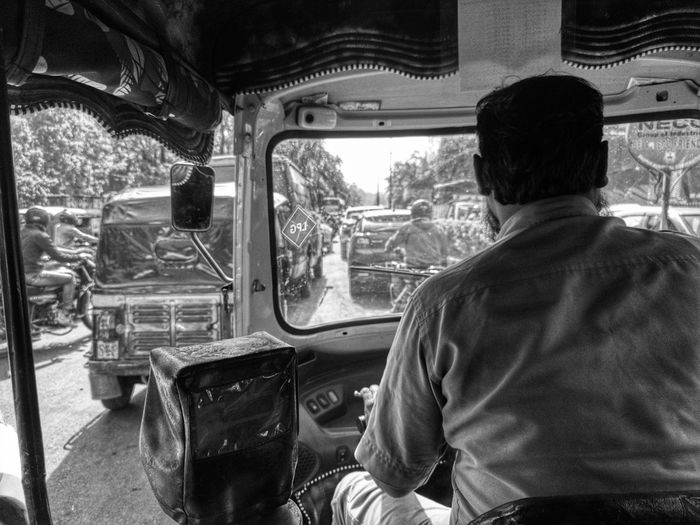 Rear view of man riding an auto rickshaw
