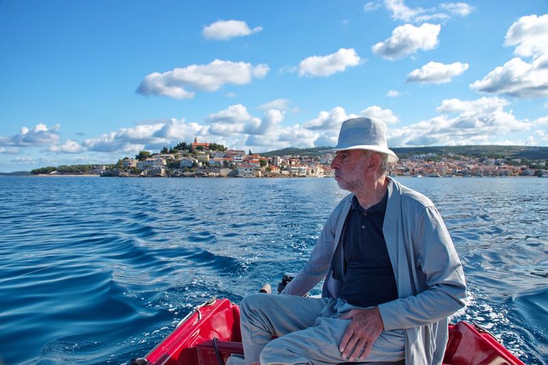 Portrait of senior man driving boat against the blue sea and blue sky