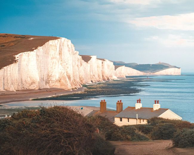 Scenic view of beach and cliffs against sky