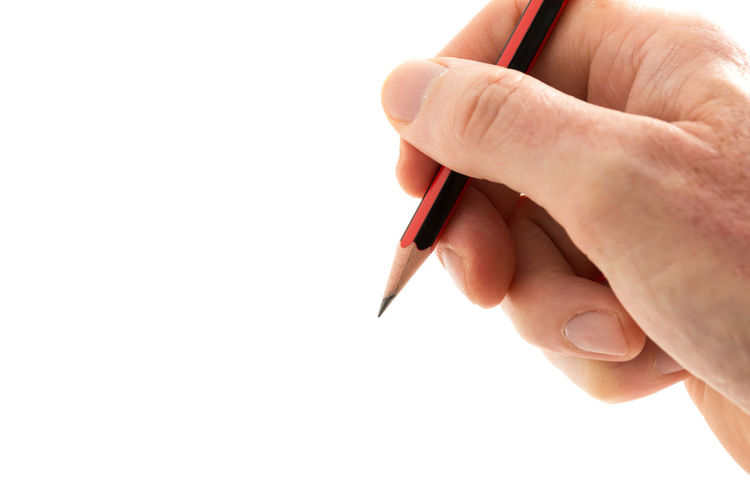 Close-up of hand holding pen against white background