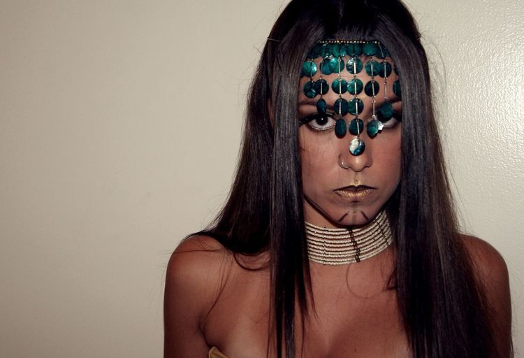 Close-up portrait of woman in tribal costume during halloween by wall