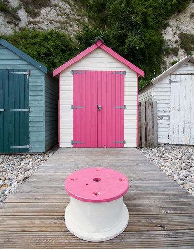 Pink stool against beach hut