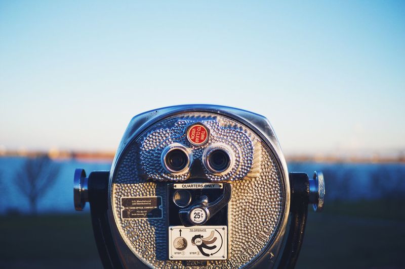 Close-up of coin-operated binoculars against cityscape