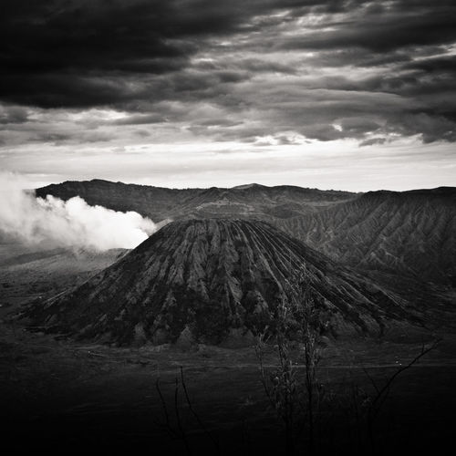 View of volcanic landscape against cloudy sky