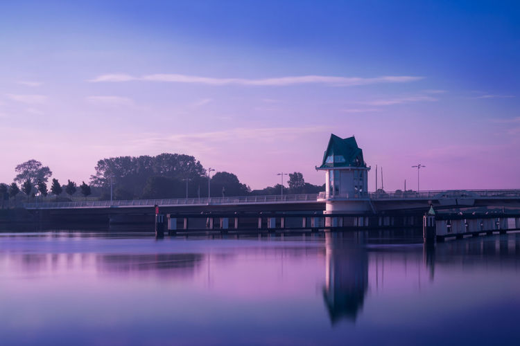 Reflection of building in river at sunset