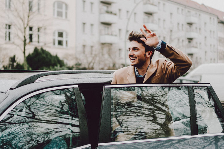 Young man photographing car on city street