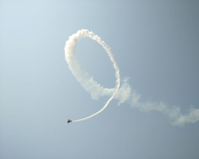 Low angle view of airshow in clear sky