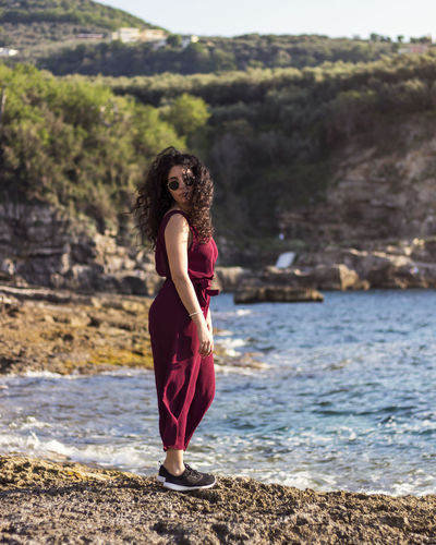 Full length portrait of woman standing at beach