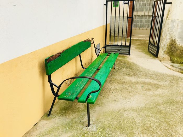 Empty chairs against wall in park