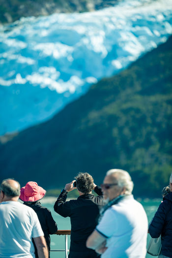 Rear view of people photographing on mountain