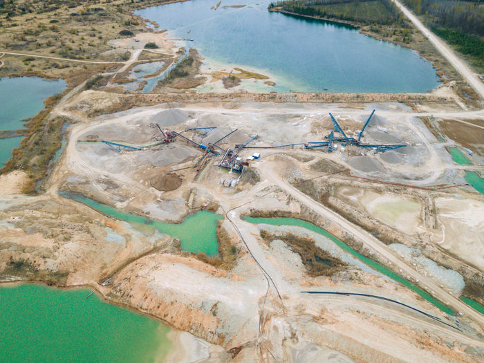 Aerial view of sand and stone quarry with tortoise color water lakes and ponds. industry of mining.