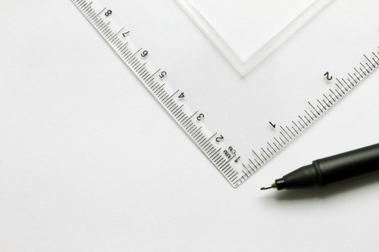 High angle view of set square with pen against white background