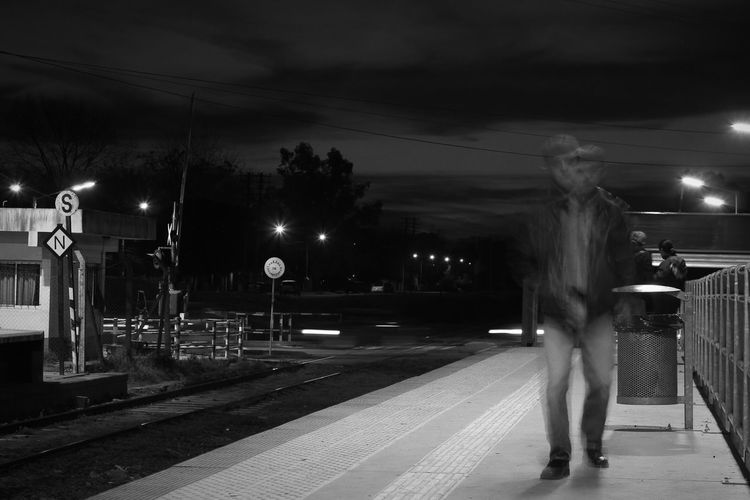 Woman standing on railroad track at night