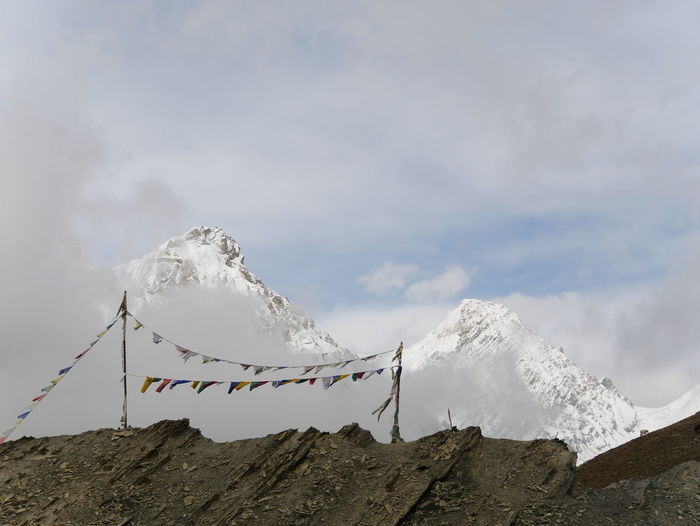 Scenic view of snowcapped mountains against sky and buddhist flags