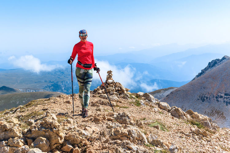 Rear view of man walking on mountain against clear sky