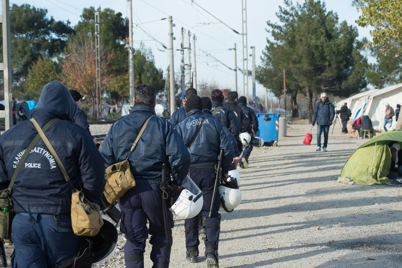 Police force walking on footpath at refugee camp