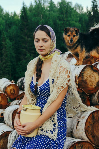 Rustic young woman in blue polka dot dress with cans