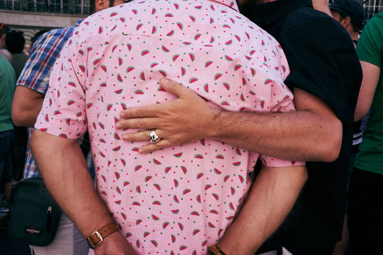 Rear view of couple standing against pink