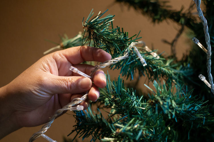 Christmas background - close up of woman decorating christmas tree