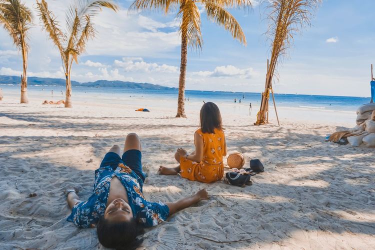 Rear view of women sitting on beach