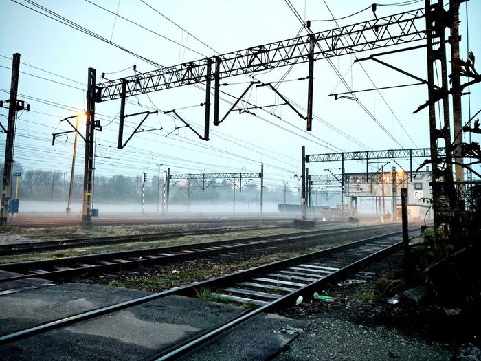 Railroad tracks against sky during morning mist