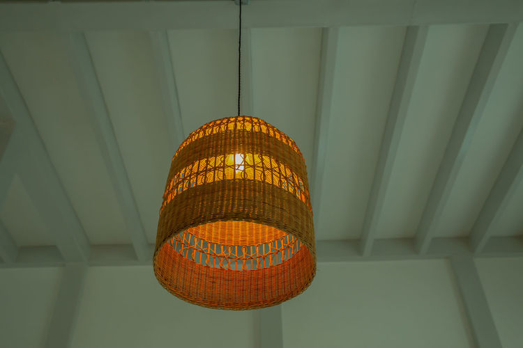 Low angle view of illuminated pendant light hanging on ceiling