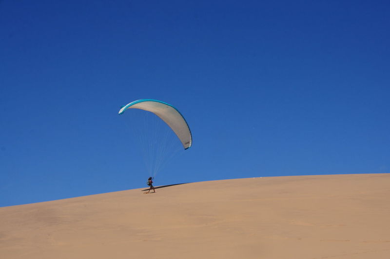 Low angle view of paraglider on desert
