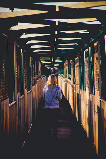 Rear view of woman crossing footbridge