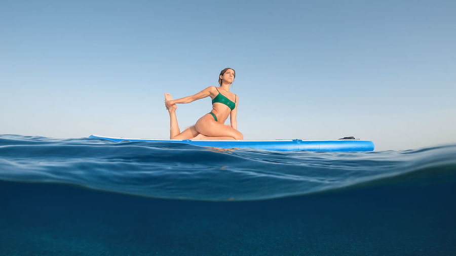 Full length of woman exercising in sea