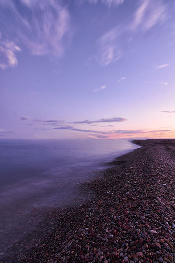 Rocky beach coast, sunset, small stones, long exposure, silk effect, infinite horizon, magenta