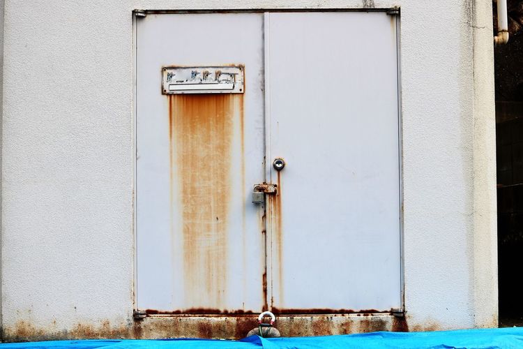 Close-up of closed rusty door of building