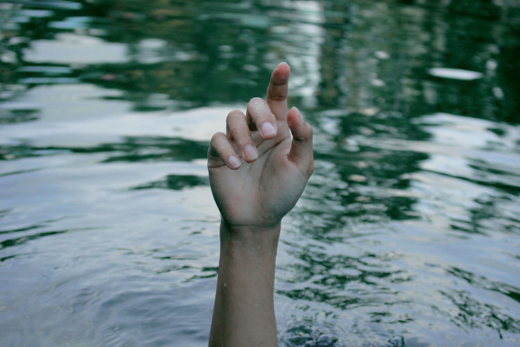 Cropped hand of woman in lake