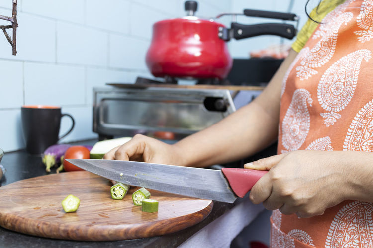 Midsection of woman preparing food in kitchen at home