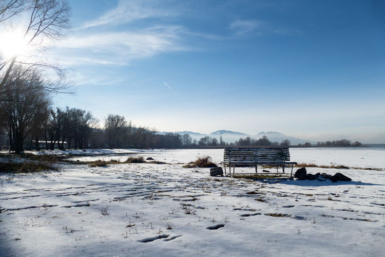 Scenic view of snow covered field against sky