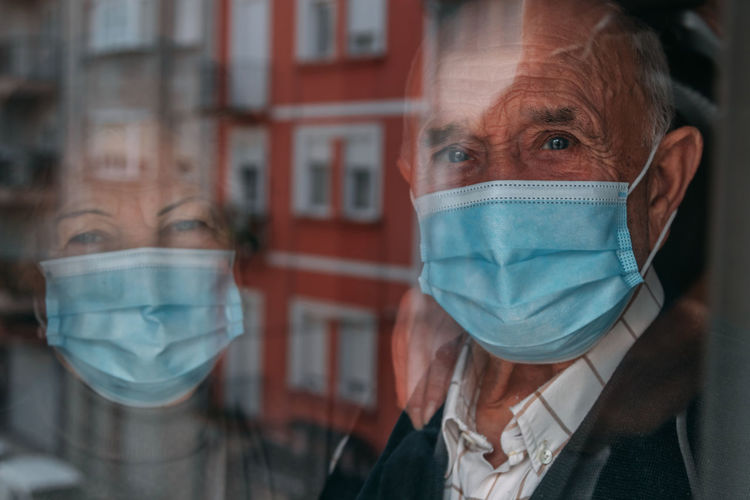Portrait of senior couple looking through window