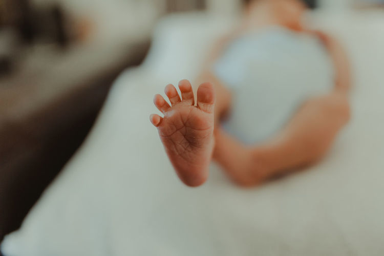 Low section of baby on bed