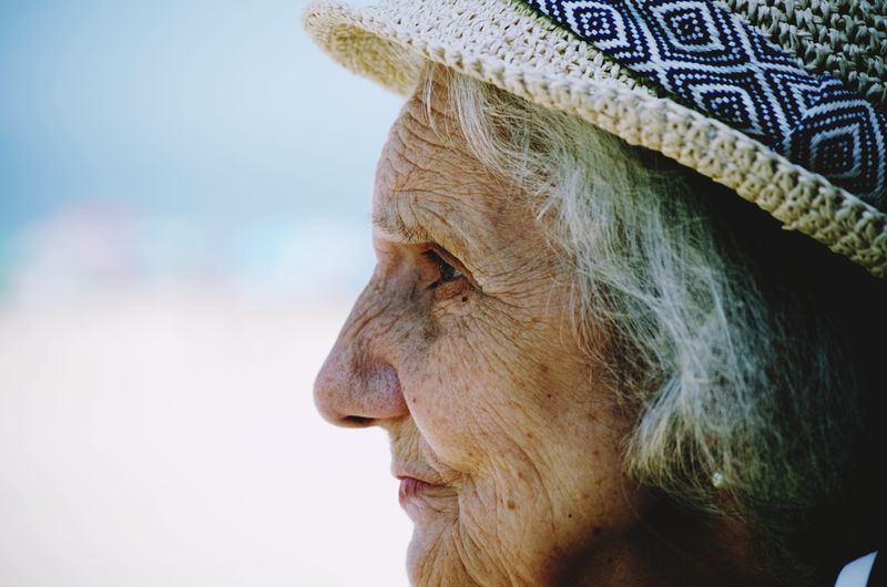 Close-up side view of senior woman wearing hat