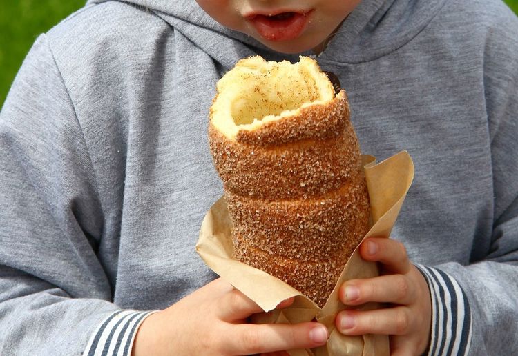 Midsection of boy eating bread roll