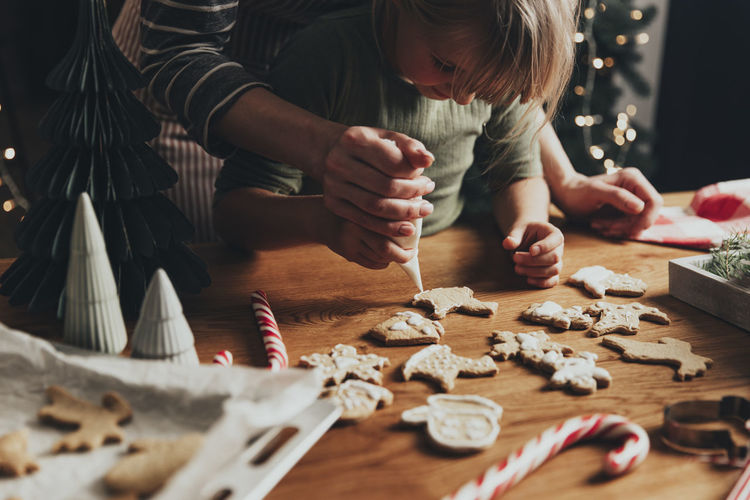 Christmas, new year food preparation. xmas gingerbread cooking, decorating cookie with icing, mastic