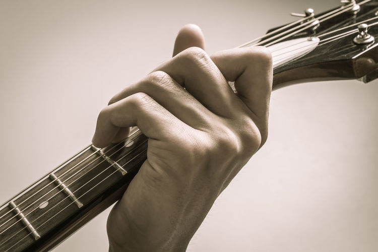 Cropped hands of man playing guitar