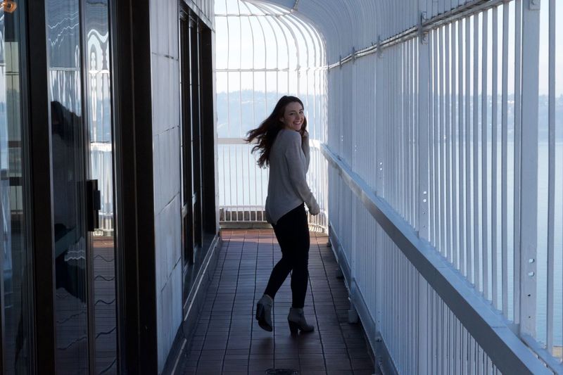 Portrait of happy young woman running in balcony at smith tower