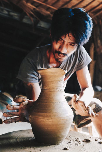 Man making pot on pottery wheel