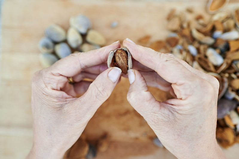 Hands of woman peeling almond
