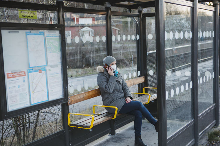 Full length of man sitting on bench in window