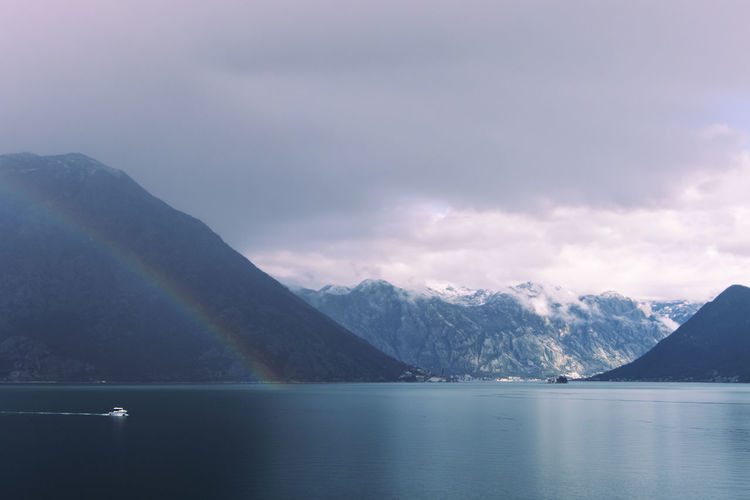 Double rainbow with dramatic clouds across the fjords of kotor bay