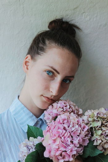 Close-up portrait of woman against white wall